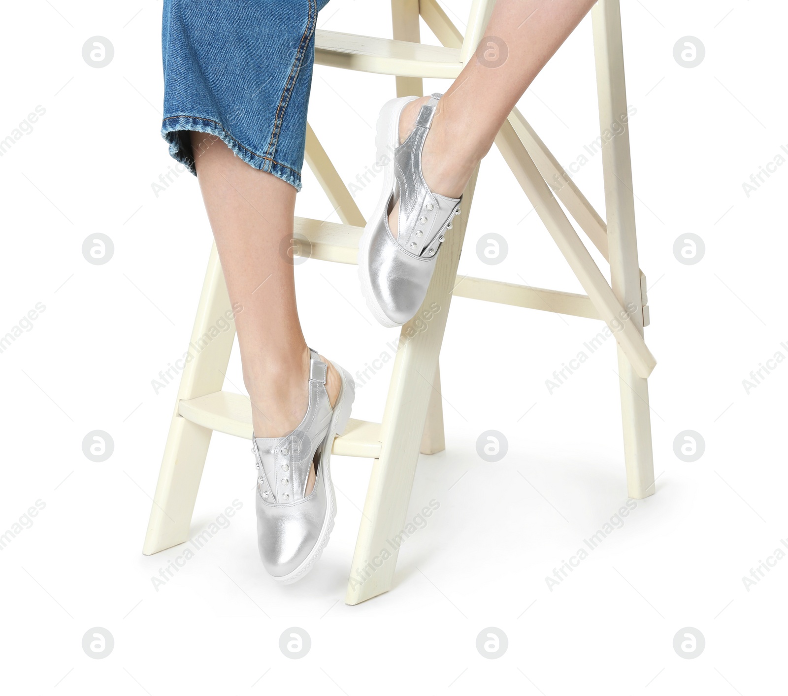 Photo of Woman in stylish shoes on ladder against white background, closeup