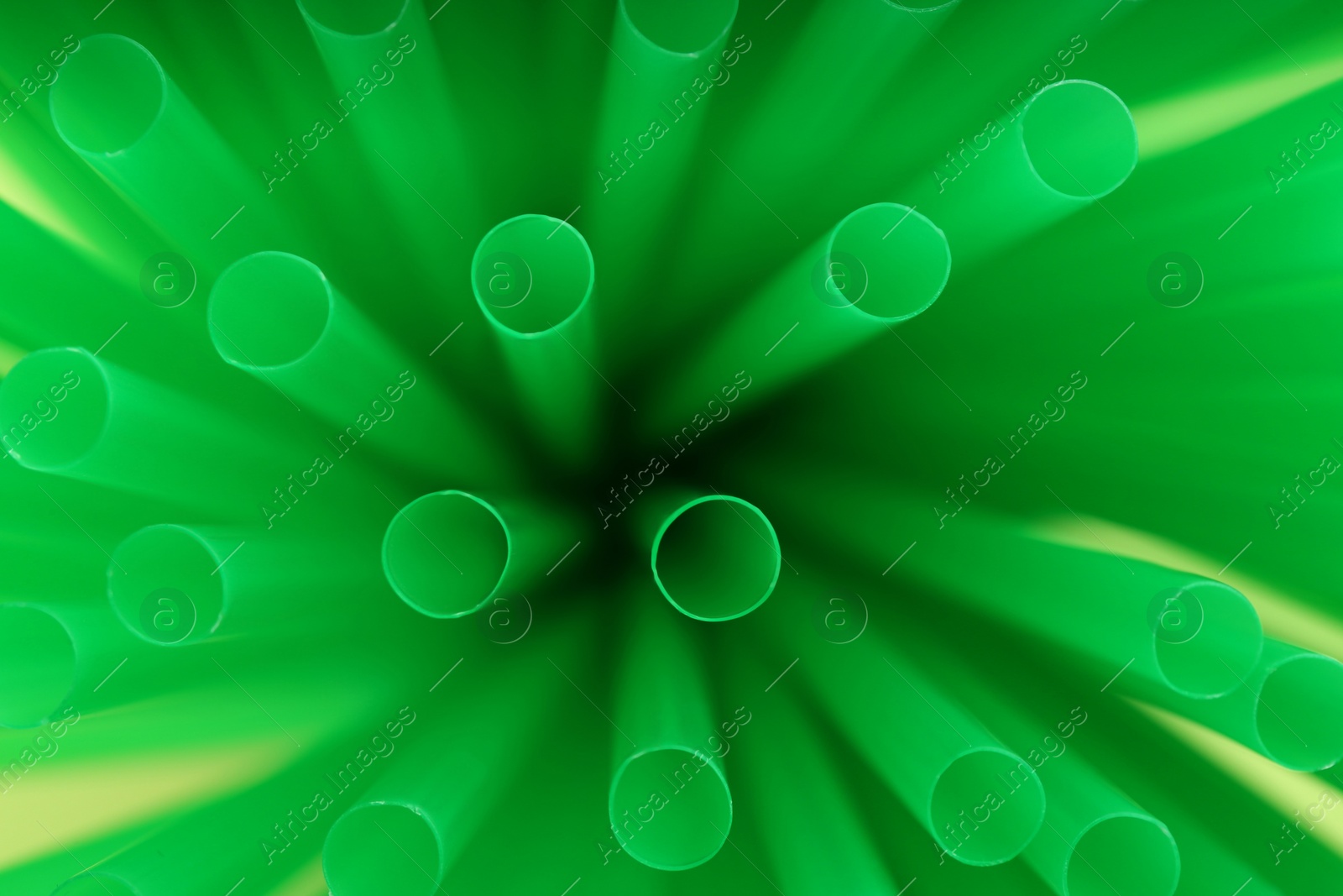 Photo of Heap of green plastic straws for drinks, closeup