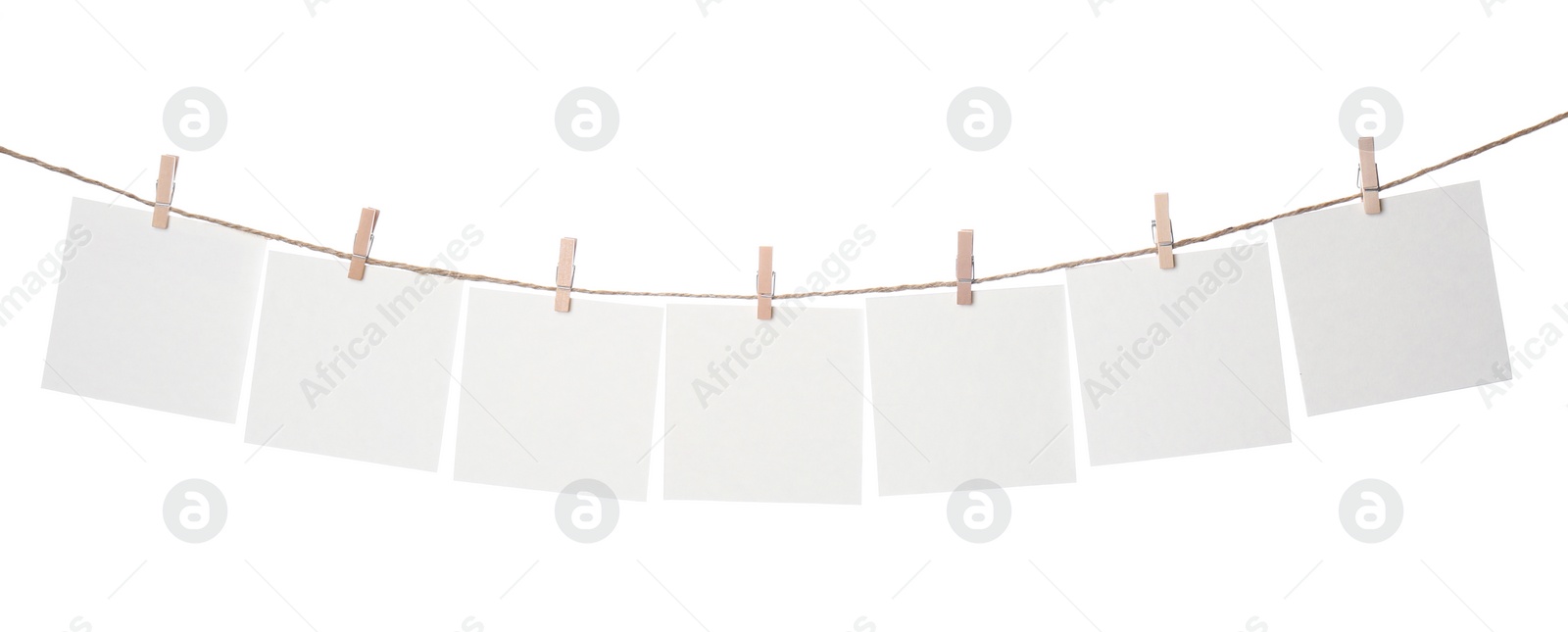 Photo of Clothespins with empty notepapers on string against white background. Space for text