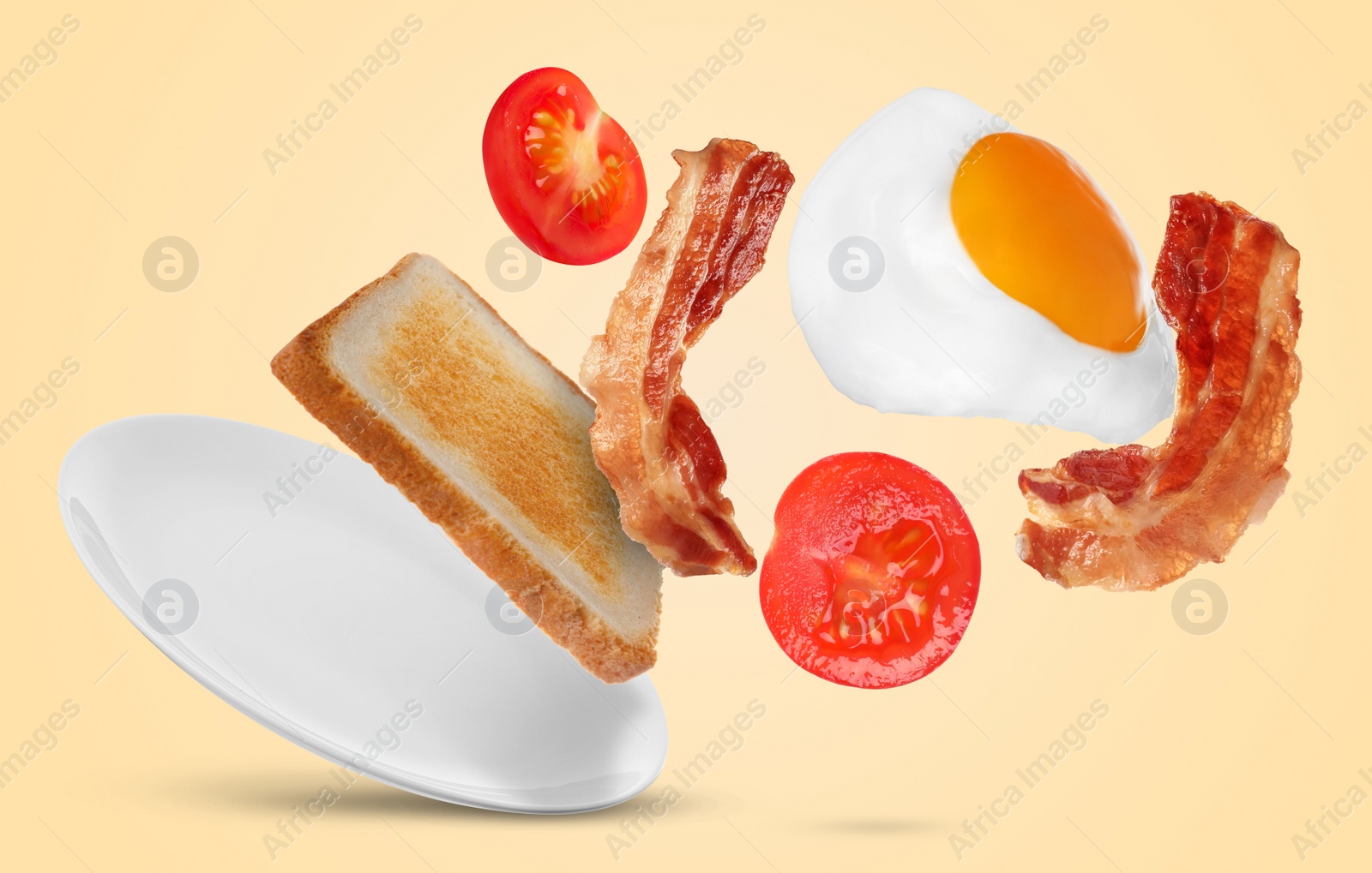 Image of Tasty fried chicken egg, bacon, tomato and toasted bread falling into plate on color background