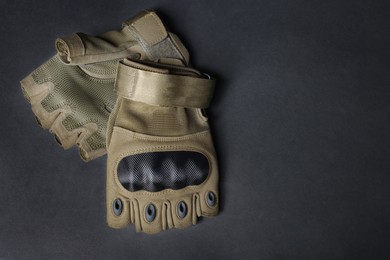 Photo of Tactical gloves on black background, flat lay with space for text. Military training equipment