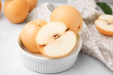 Bowl with delicious apple pears on white table