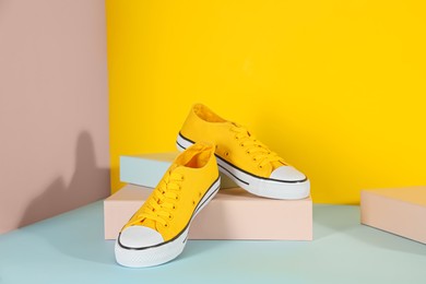 Photo of Pair of stylish sneakers on color background