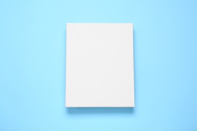Photo of Blank canvas on light blue background, top view. Space for design
