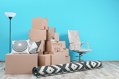 Photo of Cardboard boxes and household stuff in empty room. Moving day