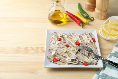 Tasty pickled anchovies served on wooden table, space for text