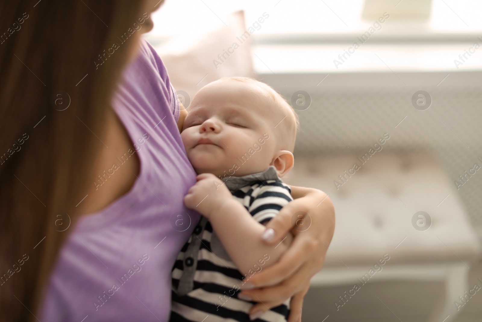 Photo of Mother with her sleeping baby at home, closeup view