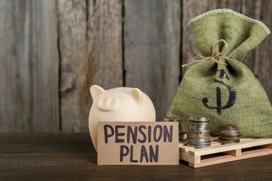 Photo of Card with phrase Pension Plan, stacks of coins, piggy bank and sack on wooden table. Retirement concept