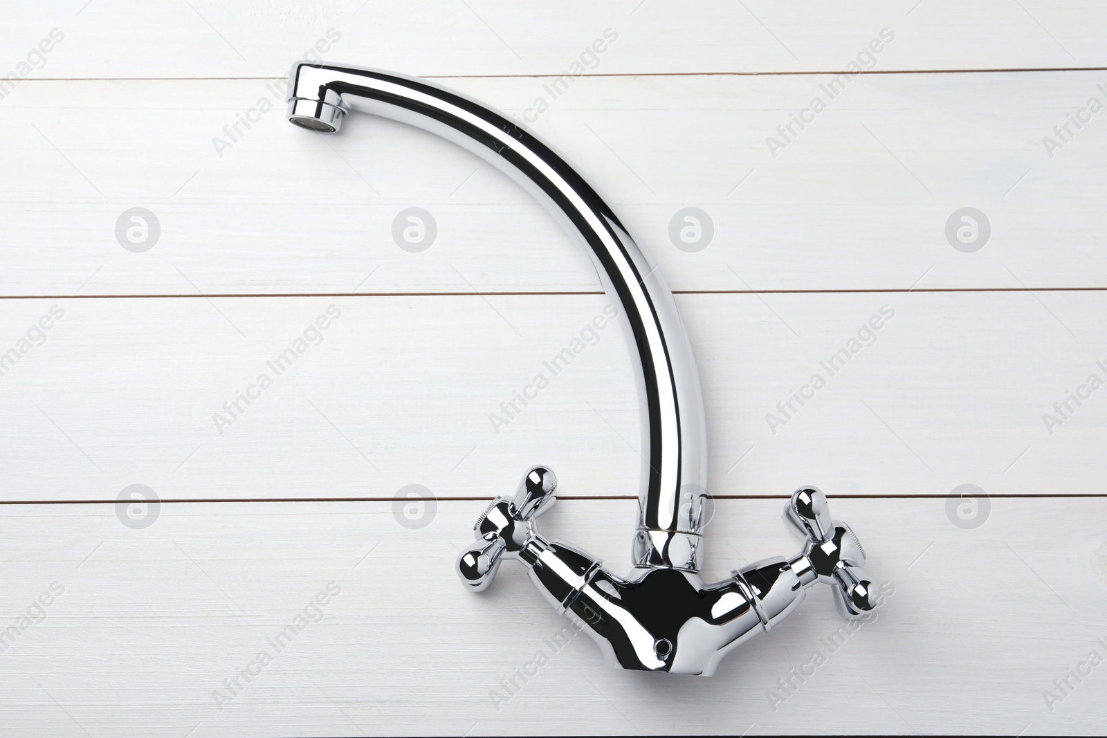 Photo of Double handle water tap on white wooden table, top view