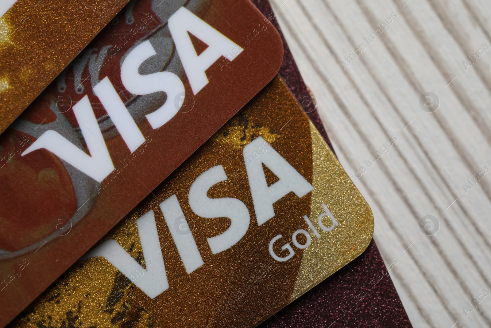 Photo of MYKOLAIV, UKRAINE - FEBRUARY 22, 2022: Visa credit cards on white wooden table, closeup