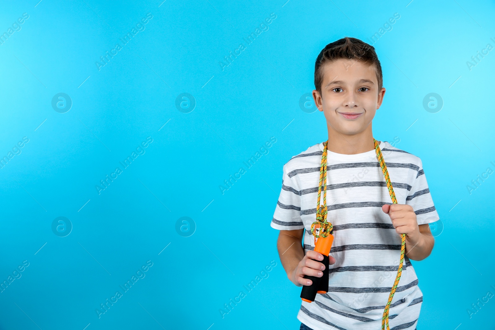 Photo of Boy with jump rope on color background. Space for text