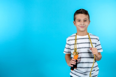 Photo of Boy with jump rope on color background. Space for text