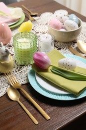 Photo of Festive table setting with painted eggs. Easter celebration