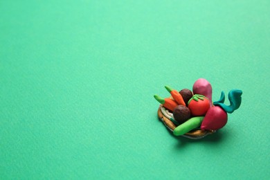 Photo of Different plasticine vegetables on light green background, top view with space for text. Children's handmade ideas