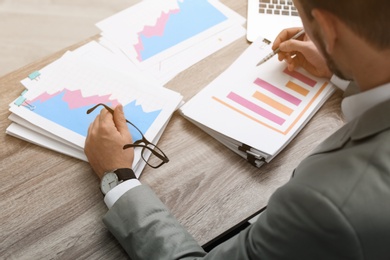 Photo of Businessman working with documents at office table, closeup