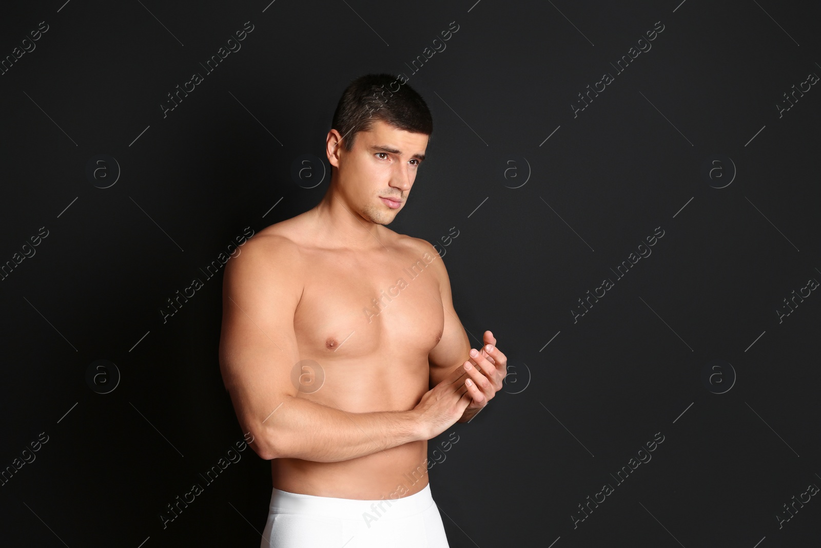 Photo of Man with sexy body on black background. Space for text