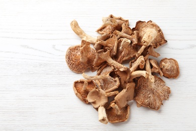 Photo of Dried mushrooms on wooden background, top view. Space for text