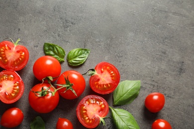 Flat lay composition with ripe cherry tomatoes and basil leaves on color background. Space for text