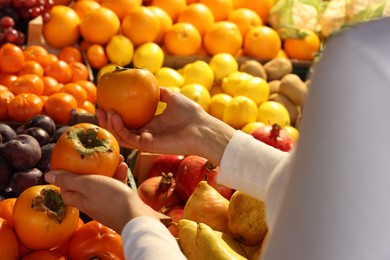 Photo of Woman picking fresh fruits at market, closeup