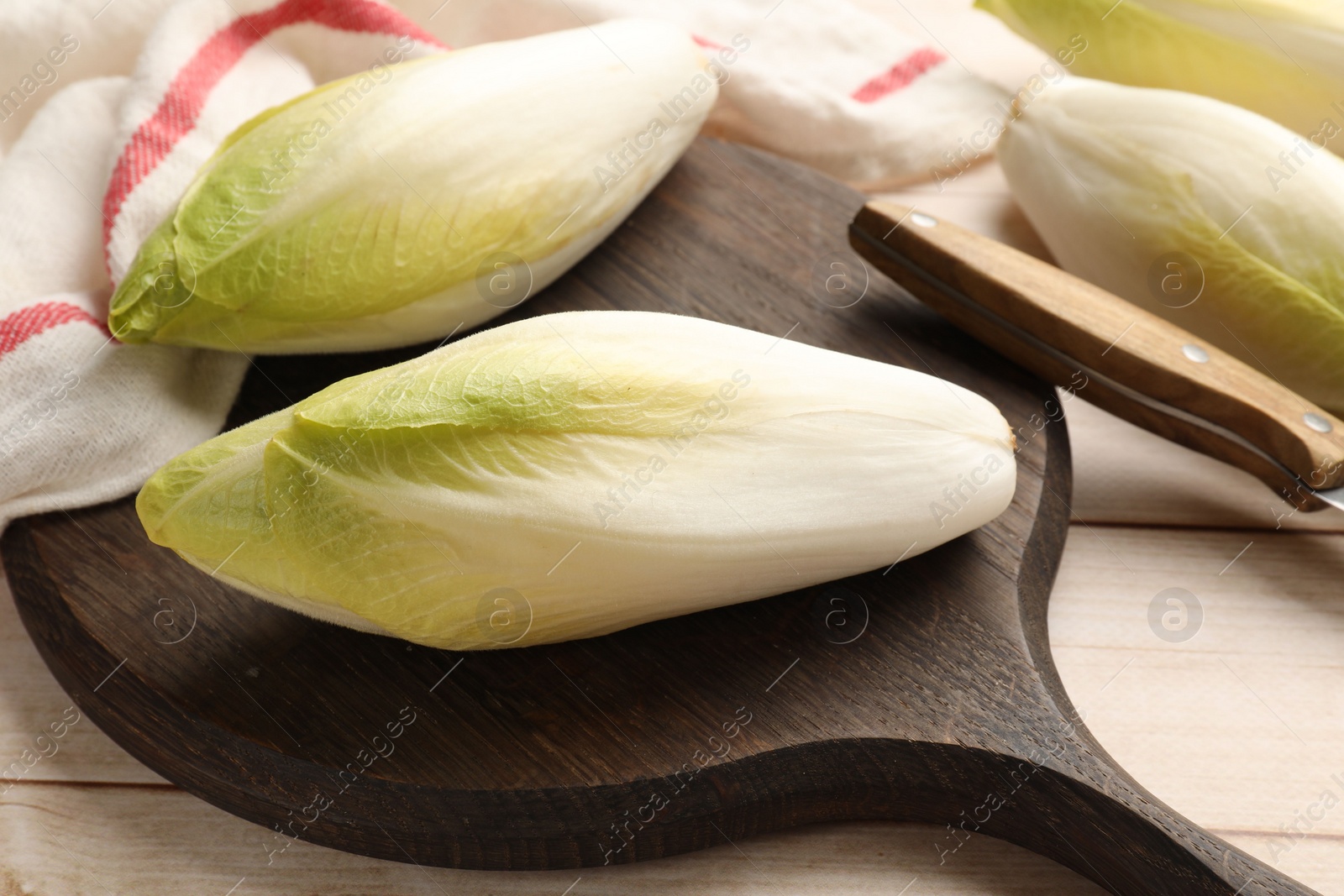 Photo of Raw ripe chicories on wooden table, closeup