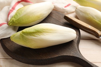 Photo of Raw ripe chicories on wooden table, closeup