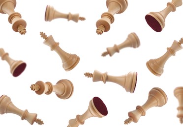 Wooden chess kings falling on white background