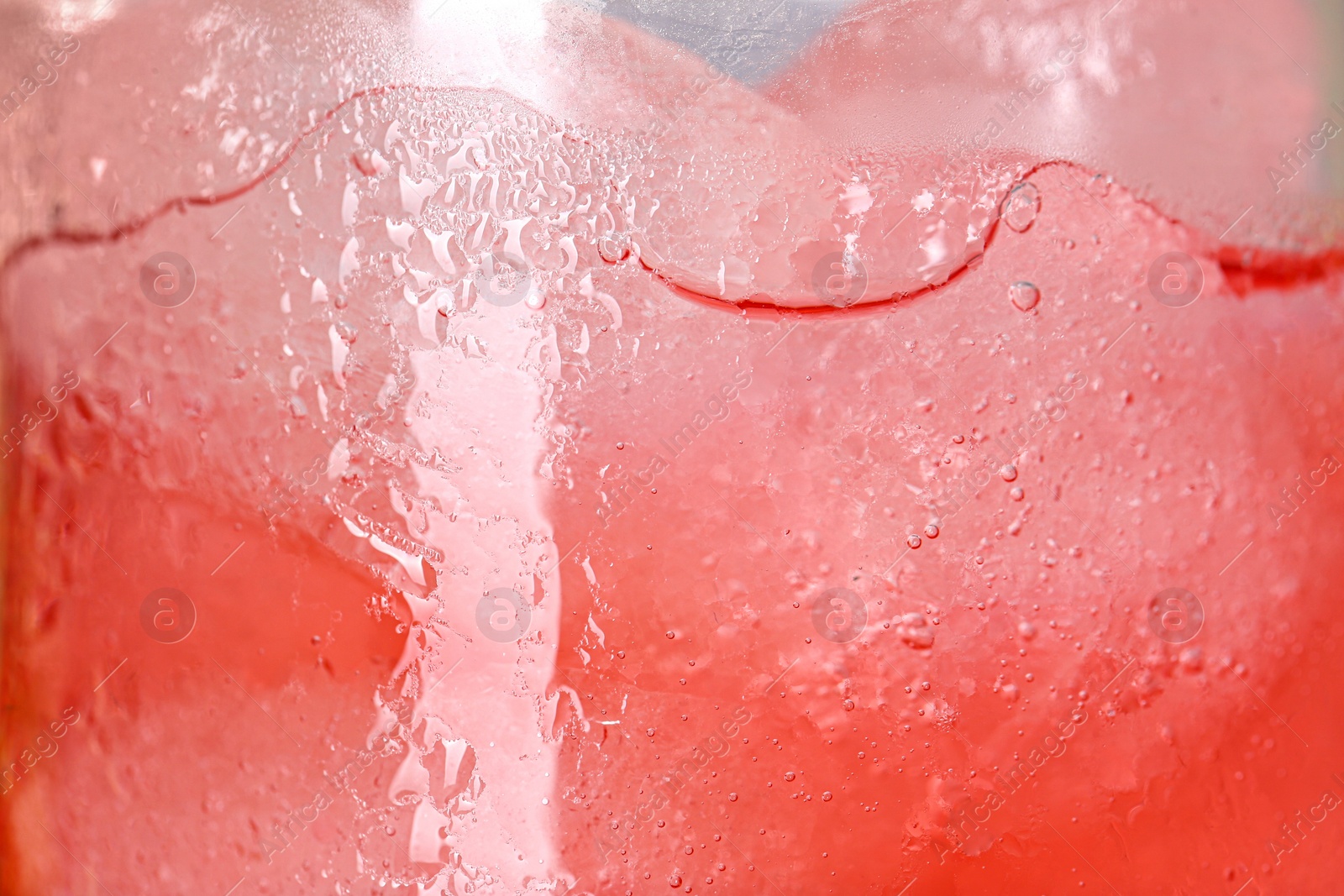 Photo of Glass of refreshing drink with ice cubes as background, closeup