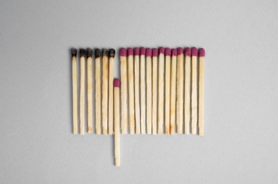 Flat lay composition with burnt and whole matches on light background