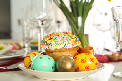 Photo of Festive table setting with Easter bread and decorated eggs, closeup