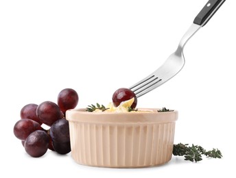 Photo of Taking tasty baked camembert with fork from bowl on white background