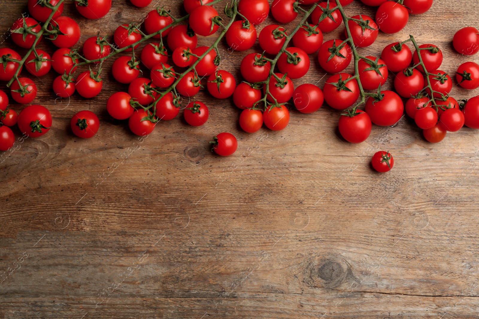 Photo of Fresh ripe cherry tomatoes on wooden table, flat lay. Space for text