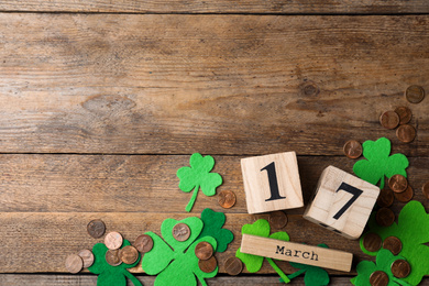 Photo of Flat lay composition with block calendar on wooden background, space for text. St. Patrick's Day celebration