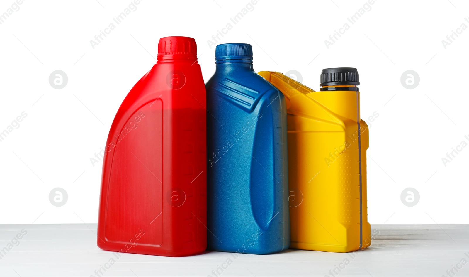 Photo of Different bottles on wooden table against white background