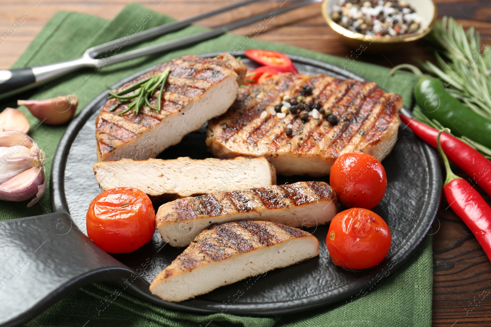 Photo of Grilled pork steaks with rosemary, spices and vegetables on table, closeup