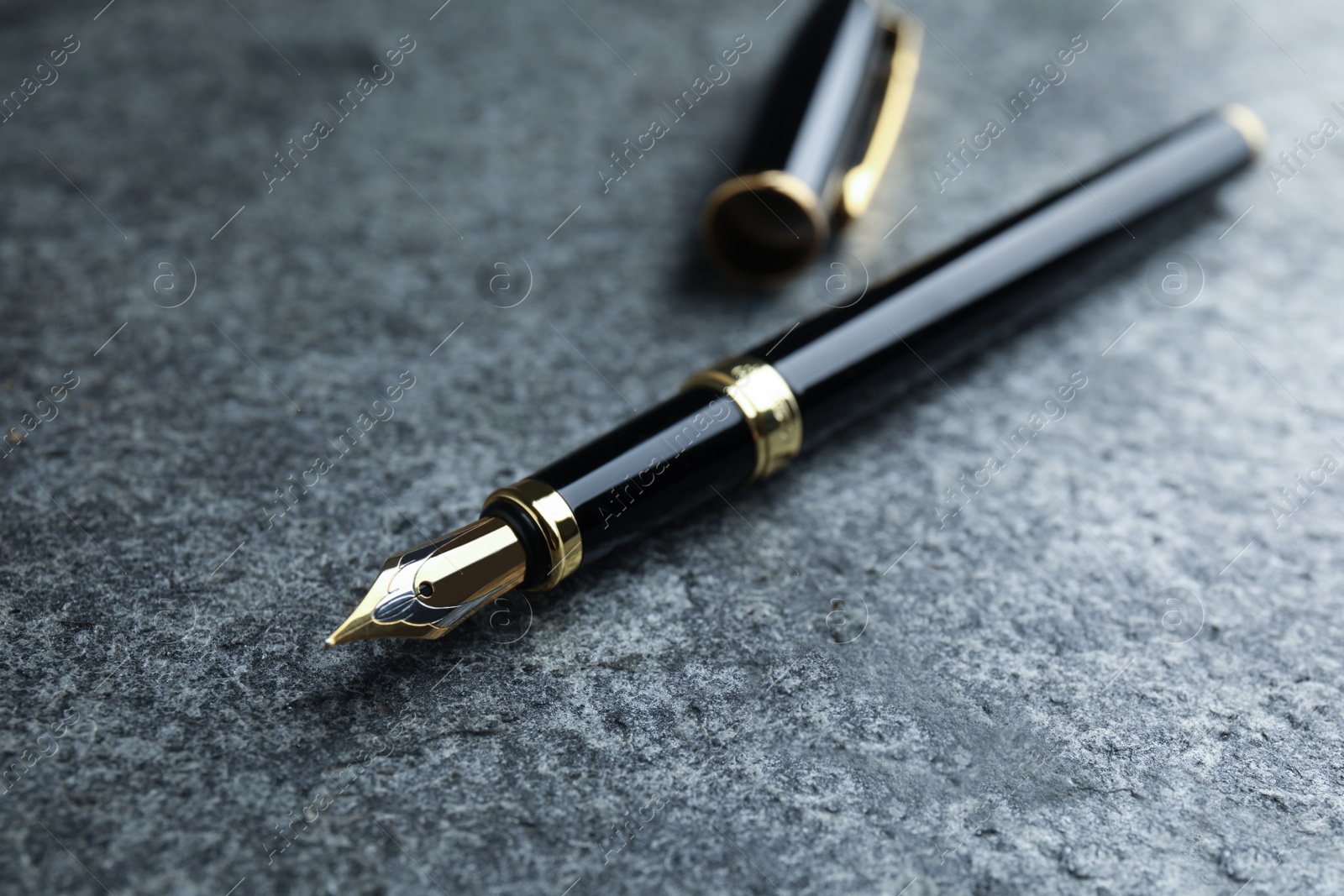 Photo of Beautiful fountain pen with ornate nib on grey table, closeup