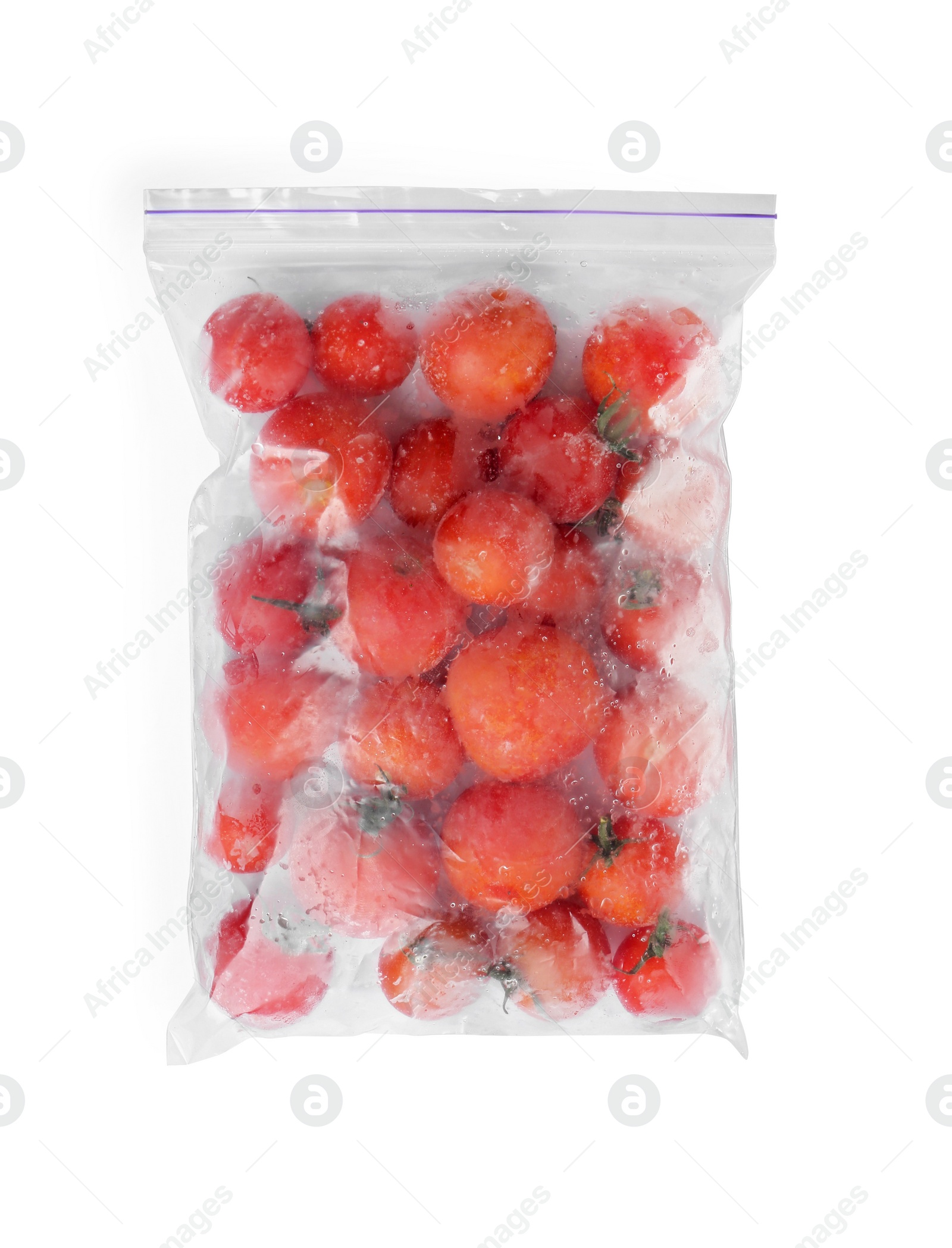 Photo of Frozen tomatoes in plastic bag isolated on white, top view. Vegetable preservation