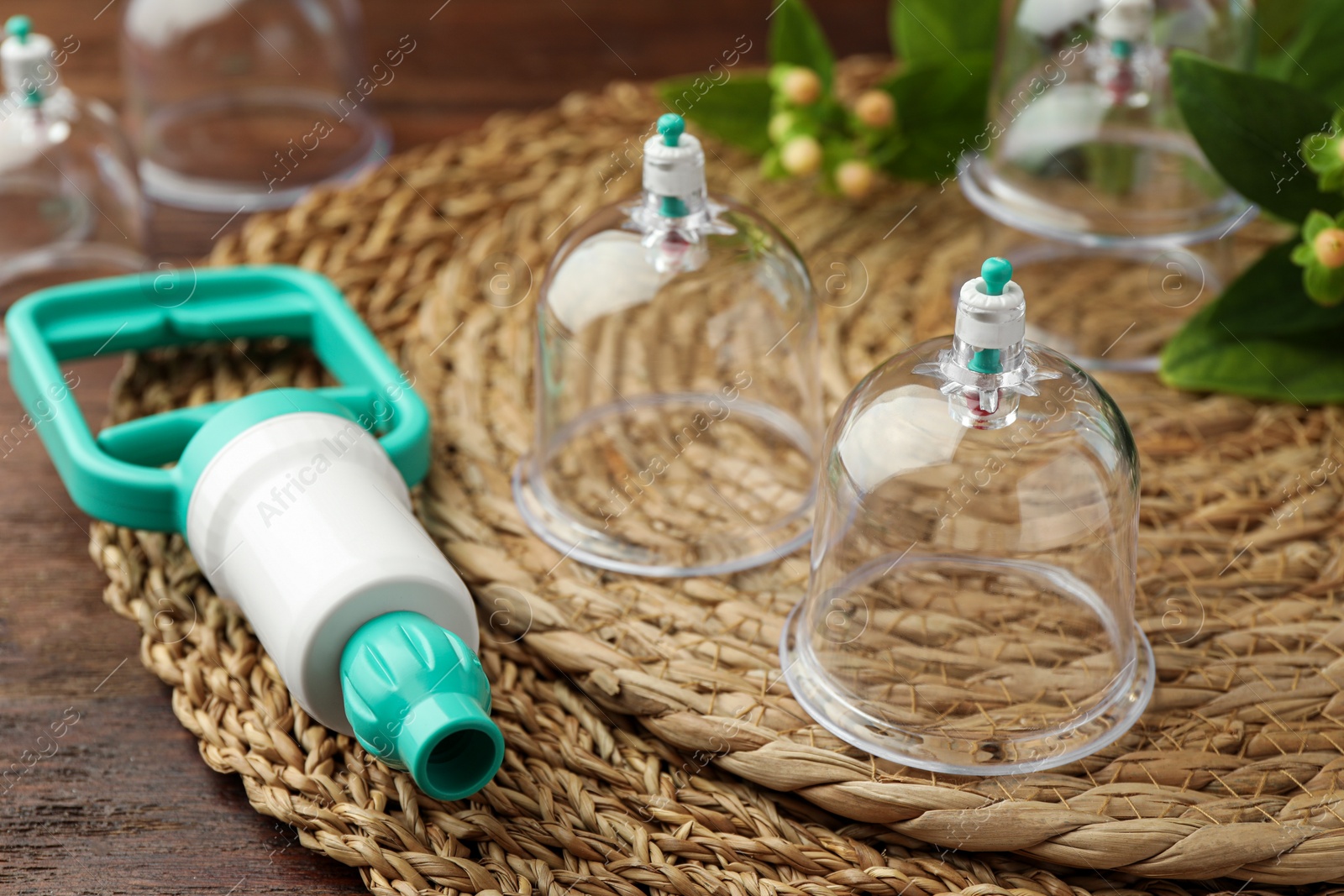 Photo of Cupping therapy. Plastic cups and hand pump on table, closeup