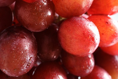 Photo of Bunch of red fresh ripe juicy grapes as background, closeup