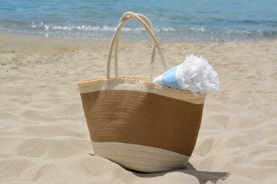 Photo of Bag with beach towel on sandy seashore
