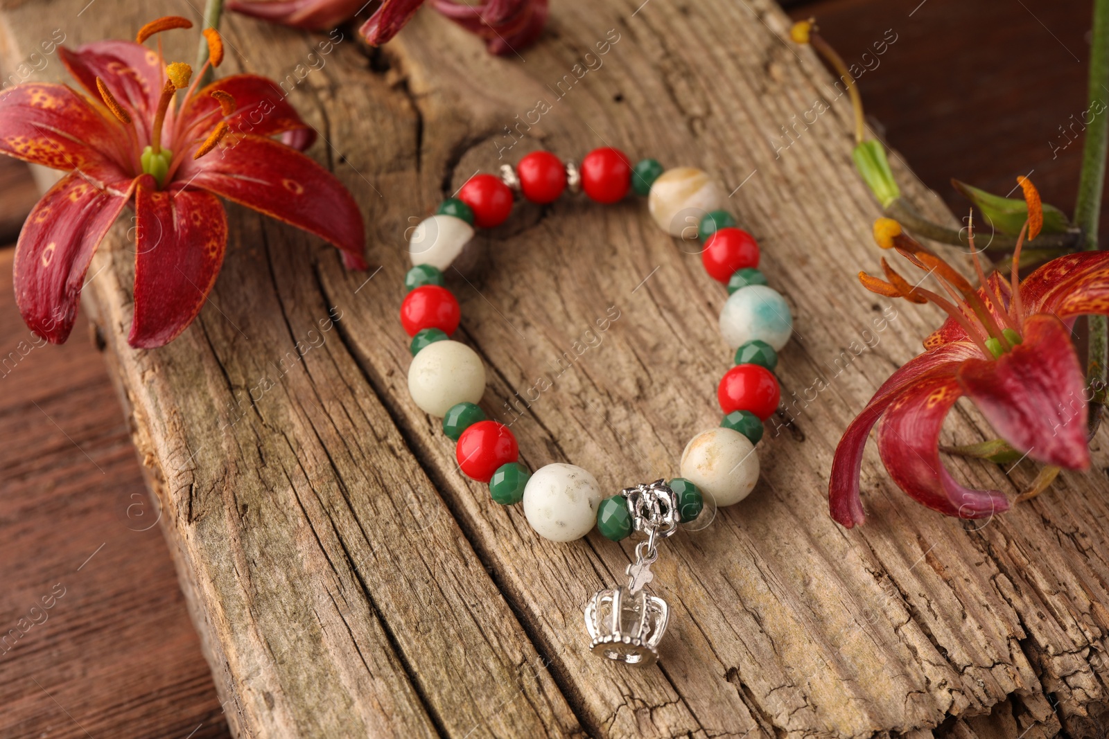 Photo of Stylish presentation of beautiful bracelet with gemstones on wooden table