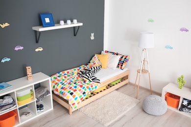 Photo of Modern room interior with comfortable bed for child