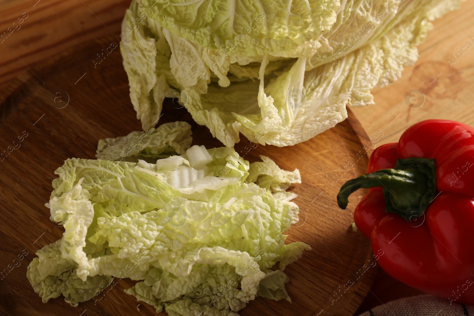 Photo of Fresh Chinese cabbage and pepper on wooden table, closeup