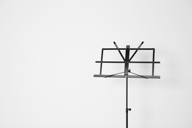 Photo of Empty music note stand on white background. Space for text