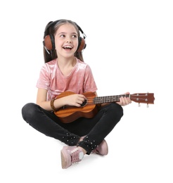 Little girl with headphones playing guitar isolated on white