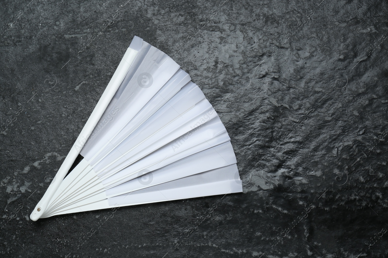 Photo of Stylish white hand fan on grey textured background, top view. Space for text