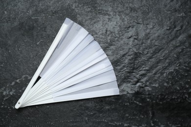 Photo of Stylish white hand fan on grey textured background, top view. Space for text