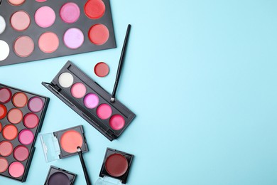 Photo of Flat lay composition with cream lipstick palettes on light turquoise background, space for text. Professional cosmetic product