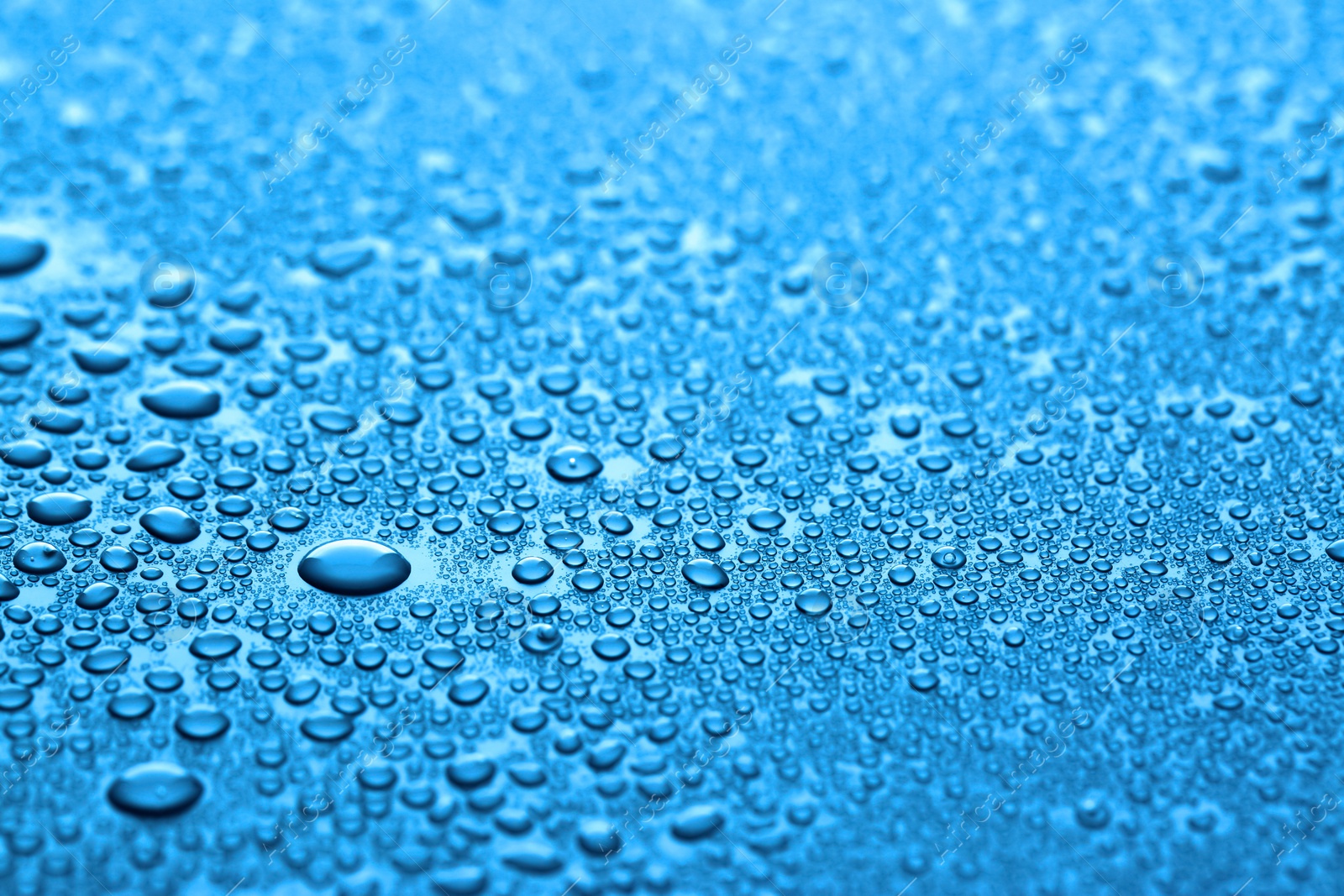 Photo of Many water drops on dark dusty blue background, closeup