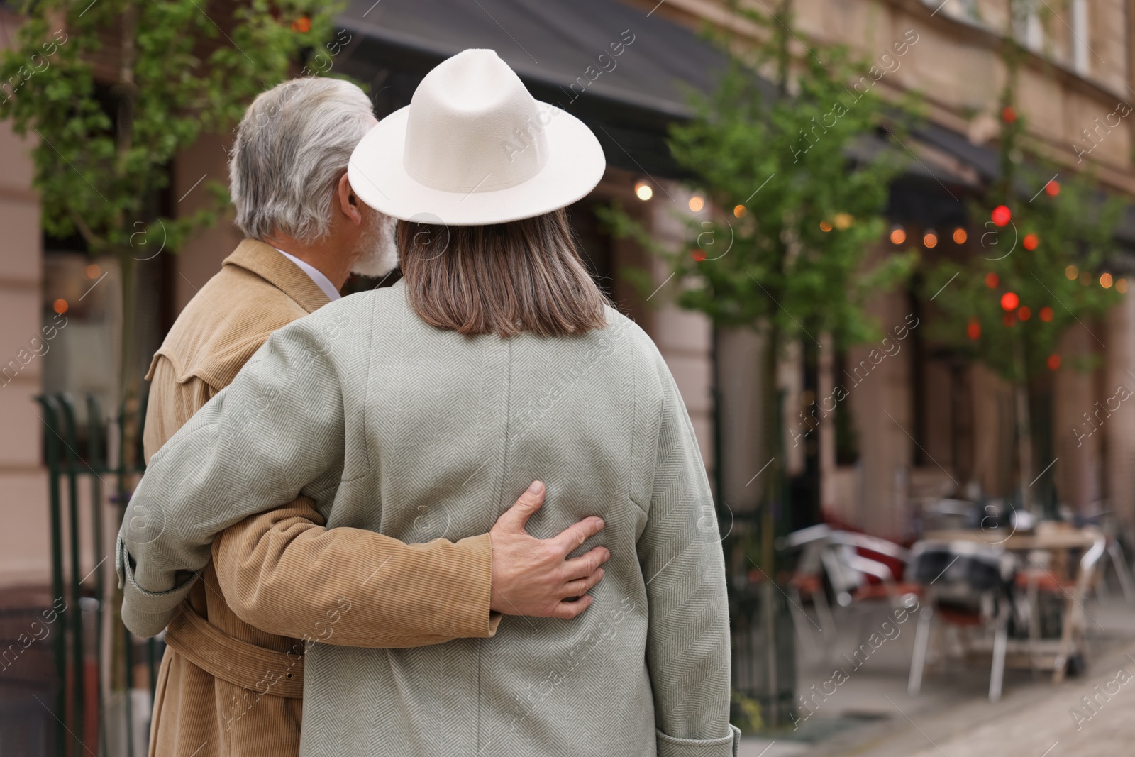 Photo of Affectionate senior couple walking outdoors, back view. Space for text