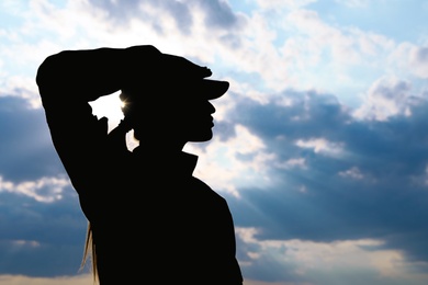 Photo of Female soldier in uniform saluting outdoors. Military service